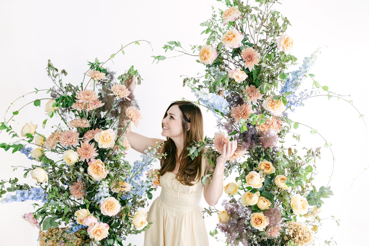 Florist surrounded by floral arch